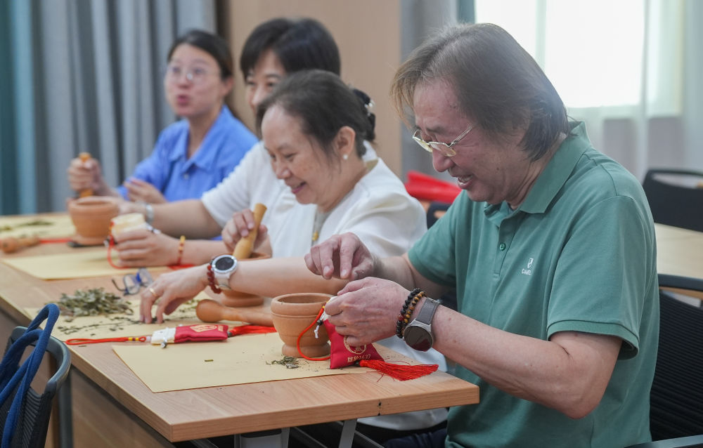 7月5日，在湖北省武汉市叶开泰中医药文化园，“海峡两岸媒体荆楚行”参访团成员体验制作香包。新华社记者 杜子璇 摄